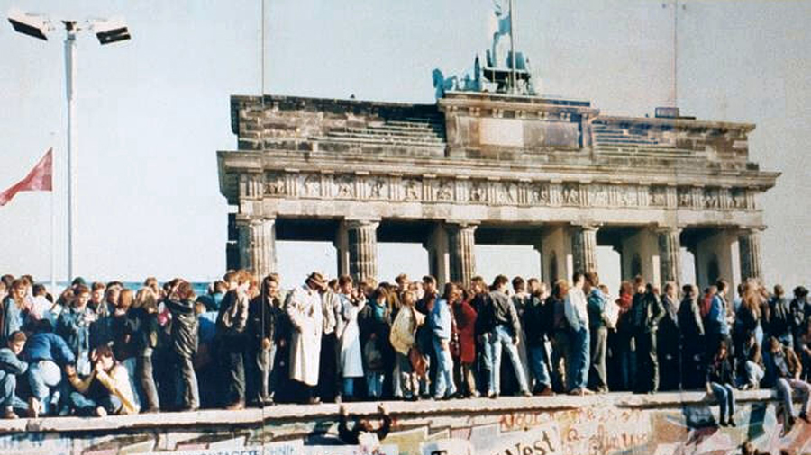 Menschen feiern auf der Mauer in Berlin